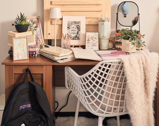 Home office desk with books, plants, and a backpack