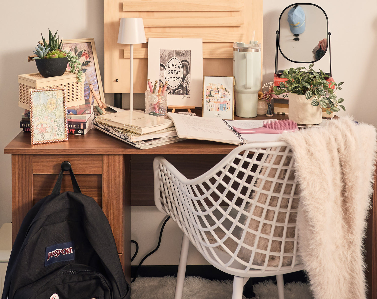 Home office desk with books, plants, and a backpack